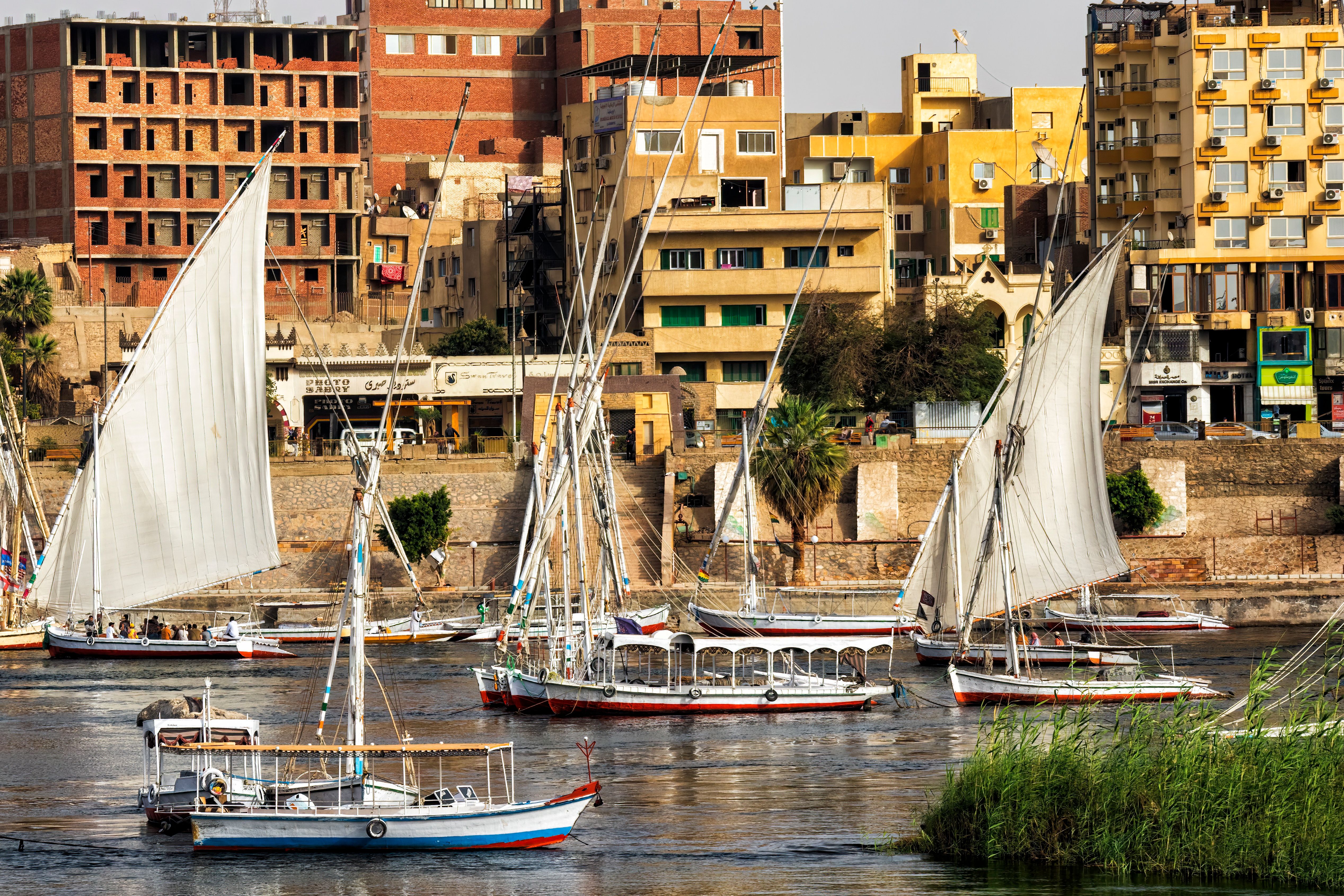 Traditional feluccas sail along the Nile at Aswan, a slower-paced stop on an Egypt vacation.