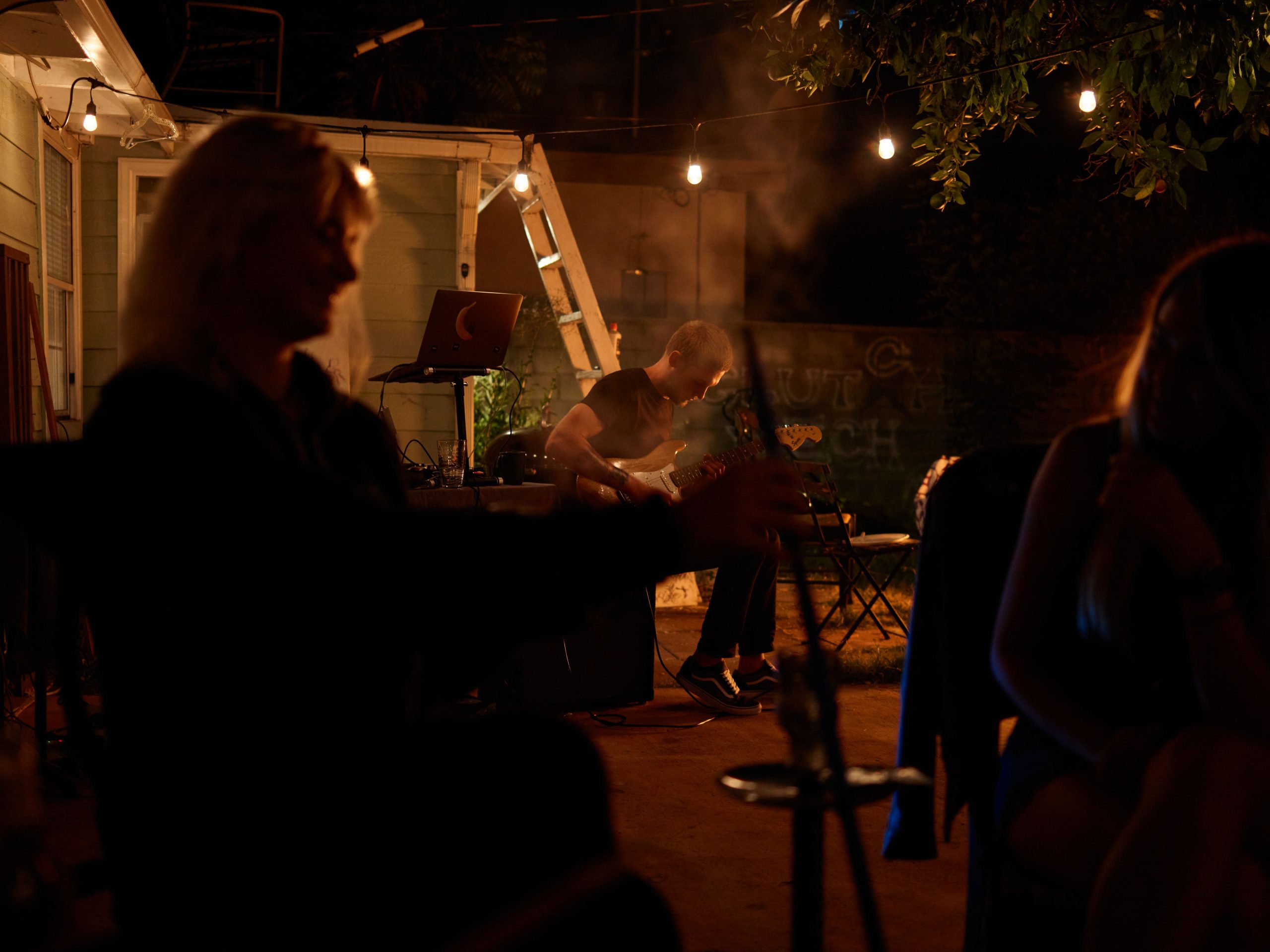 Backyard jam session with an acoustic guitar and warm nighttime lighting