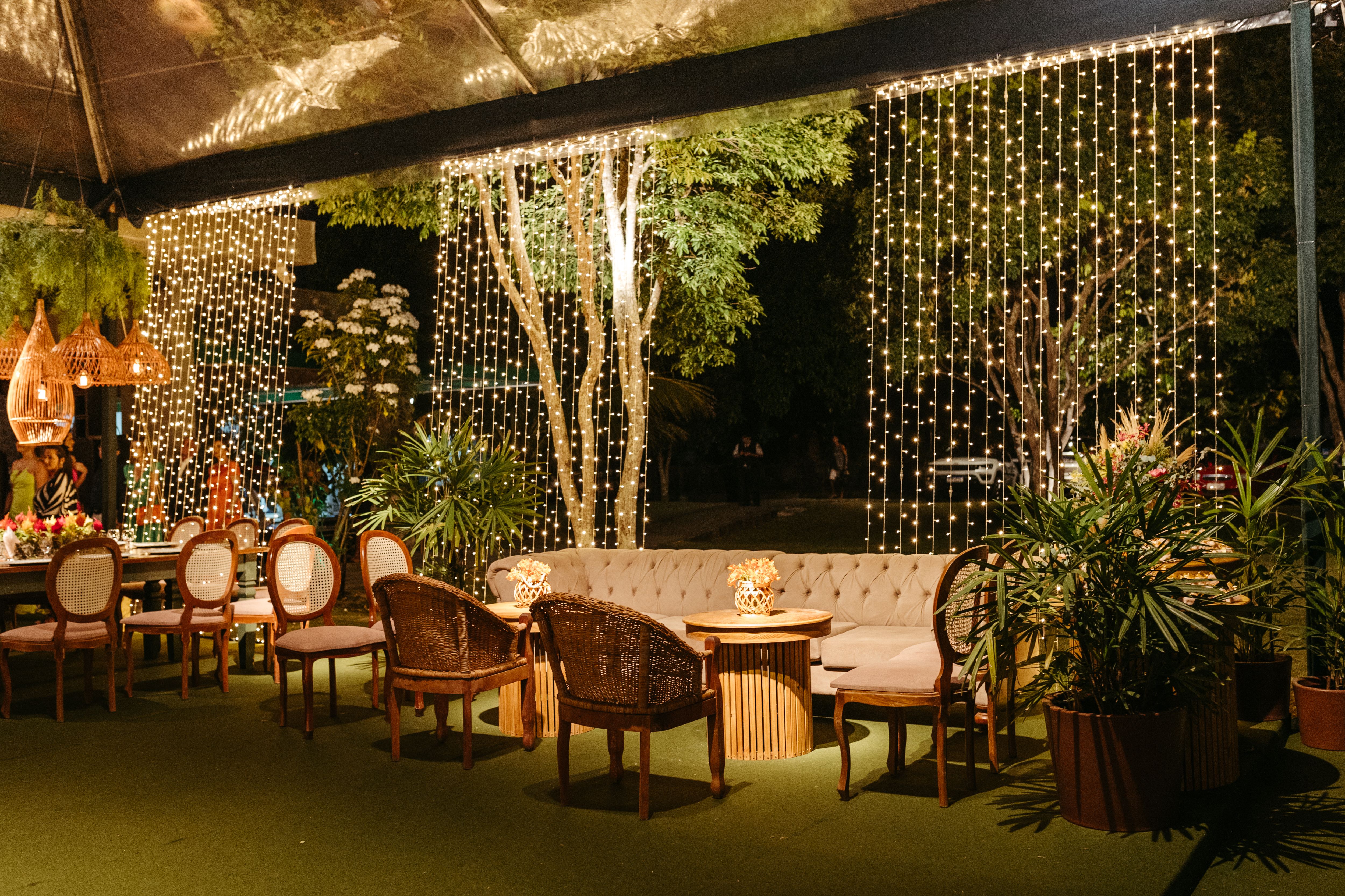Cozy outdoor seating area surrounded by greenery and evening lights