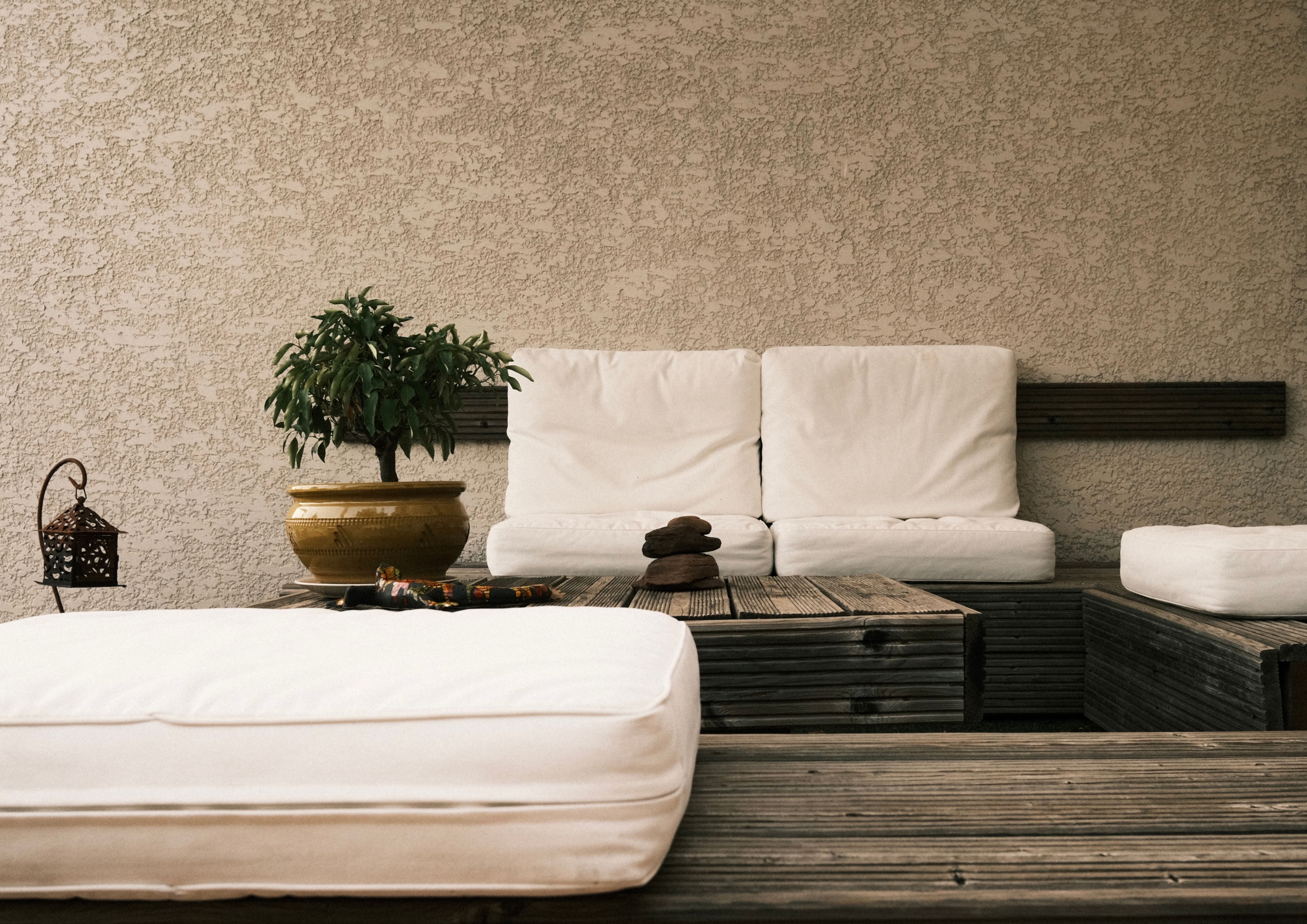 Minimalist patio lounge with white cushions and natural wood decor